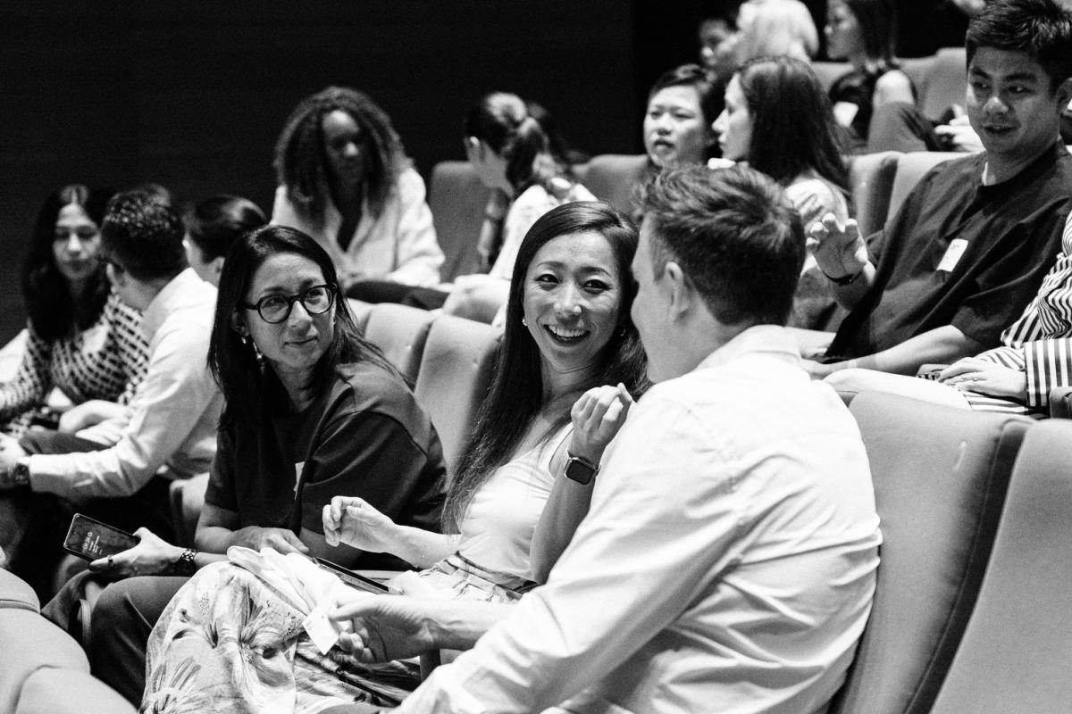 People in auditorium talking and smiling